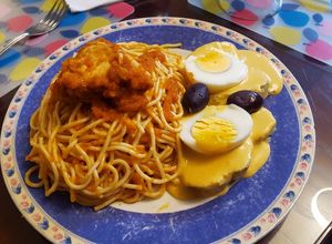 Una foto de Tallarines rojos con pollo y papa a la huancaina
