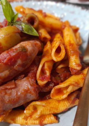 Una foto de Garganeli con salchichas y aceitunas con salsa de tomate picante