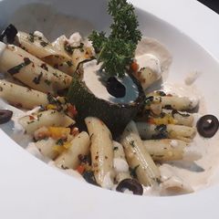 A picture of Penne aglio olio with backed zucchini and cheese mushroom sauce.