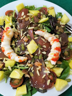 Una foto de Ensalada de brotes con langostinos, mojama y mango