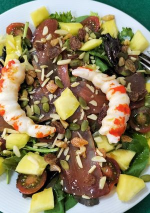 Una foto de Ensalada de brotes con langostinos, mojama y mango