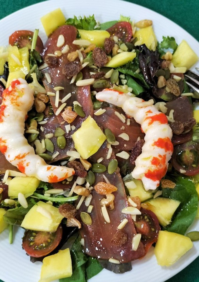 Una foto de Ensalada de brotes con langostinos, mojama y mango