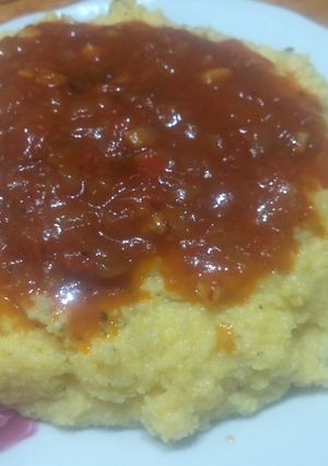 Una foto de Polenta, orégano, queso cremoso y tuco casero