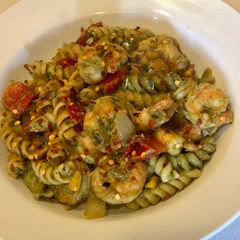 A picture of Penne Pasta with Shrimps, fire roasted red peppers, sautéed onions, corn in Avacado Lime Pesto Sauce.