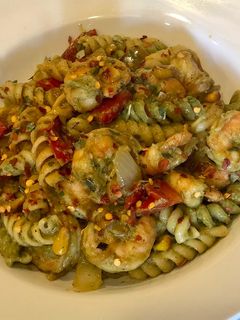 A picture of Penne Pasta with Shrimps, fire roasted red peppers, sautéed onions, corn in Avacado Lime Pesto Sauce.