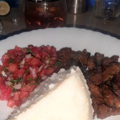 A picture of White Ugali With Dry Fried Beef and Kachumbari.