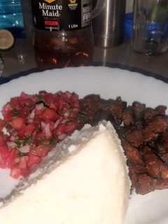 A picture of White Ugali With Dry Fried Beef and Kachumbari.
