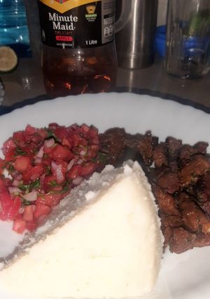 A picture of White Ugali With Dry Fried Beef and Kachumbari.