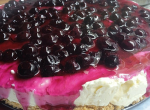 Una foto de Cheesecake sin horno con salsa de arándanos casera