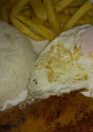 Una foto de Milanesa de Merluza con huevo y 2 guarniciones