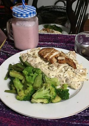 A picture of White sauce pasta with baked chicken and strawberry milkshake.
