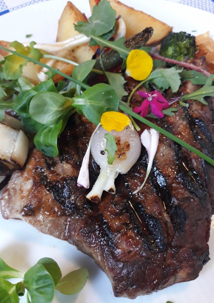 Una foto de Solomillo a la brasa con ensalada de brotes tiernos