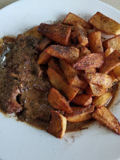 Una foto de Carne con salsa y patatas pueblerinas