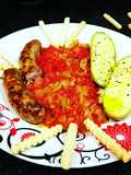 Salchichas con setas y mini calabacines en salsa de pimientos