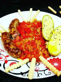Una foto de Salchichas con setas y mini calabacines en salsa de pimientos