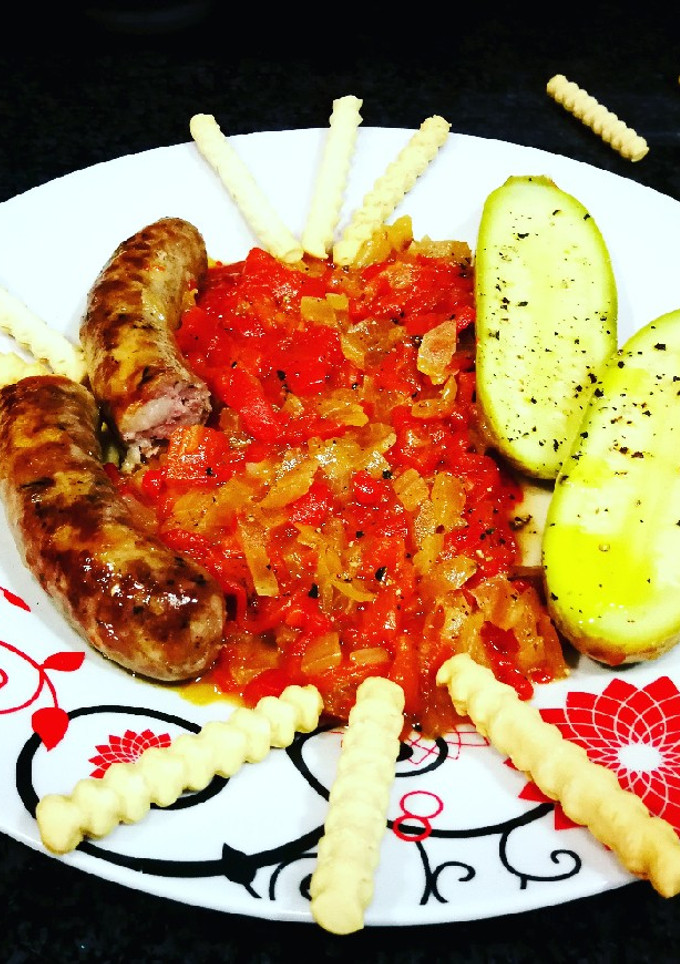 Una foto de Salchichas con setas y mini calabacines en salsa de pimientos