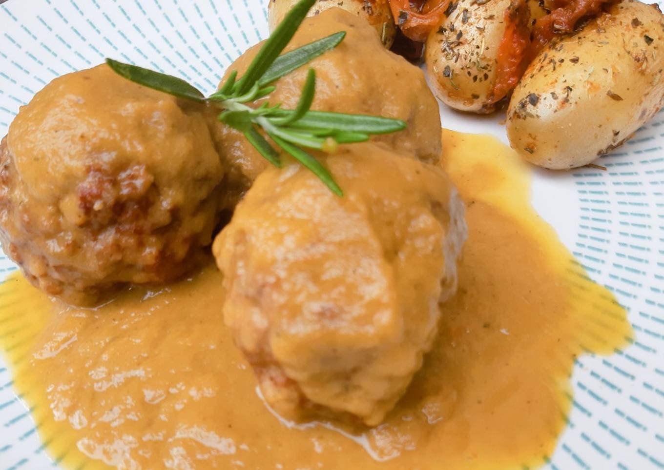 Albóndigas en salsa de cebolla con patatas guarnición y tomates