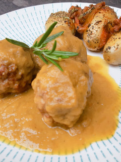 Una foto de Albóndigas en salsa de cebolla con patatas guarnición y tomates