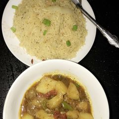 A picture of Spiced orange rice with meat and potatoes pepper soup.