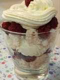 Postre de merengue, crema y frambuesas en vaso