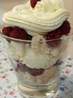 Una foto de Postre de merengue, crema y frambuesas en vaso
