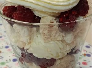 Una foto de Postre de merengue, crema y frambuesas en vaso