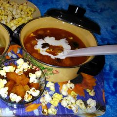 A picture of Expensive tomato soup with Fried Bread and Popcorns.