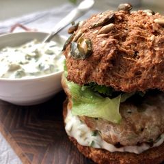 A picture of Tuna burger with tartar sauce.