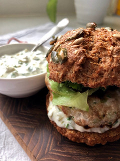 A picture of Tuna burger with tartar sauce.
