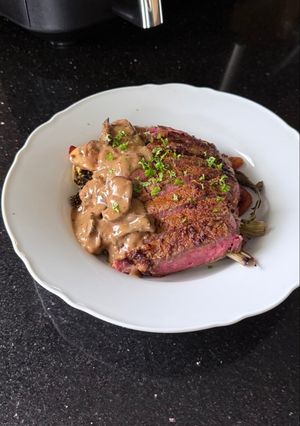 A picture of Rib Eye Steak with Wild Mushroom Sauce and Roasted Vegetables.