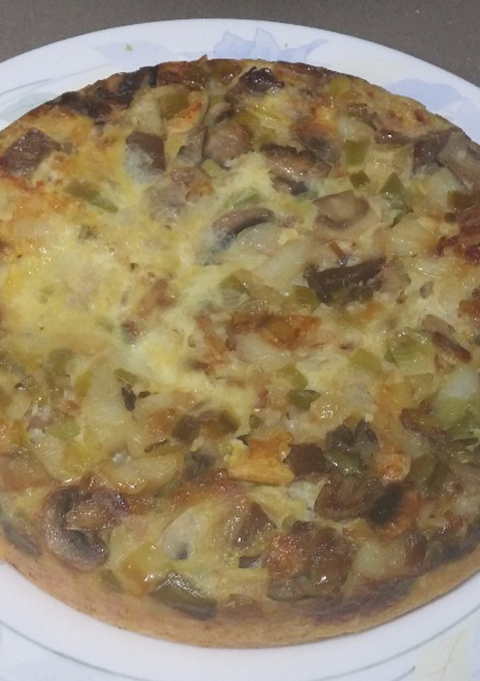 Una foto de Tortilla de patatas con ajos tiernos y setas
