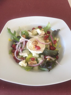 Una foto de Ensalada con queso de cabra, melón, granos de granada y cebolla