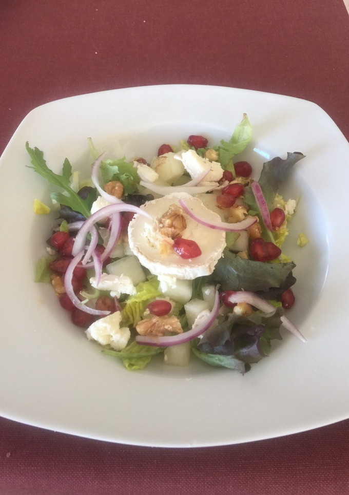 Una foto de Ensalada con queso de cabra, melón, granos de granada y cebolla