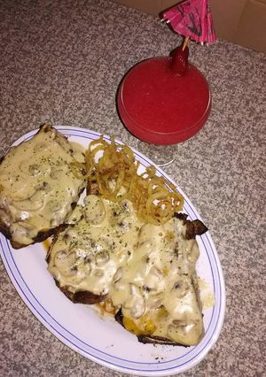 A picture of Grilled steak with homemade mushroom sauce and Spur style onion.