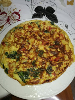 Una foto de Tortilla de pimiento, cebolla y hojas de brócoli