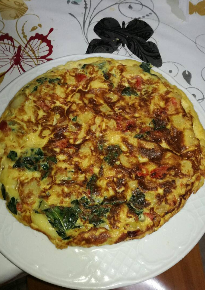 Una foto de Tortilla de pimiento, cebolla y hojas de brócoli