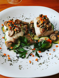 Una foto de Lomos de merluza con calabacines y boletus