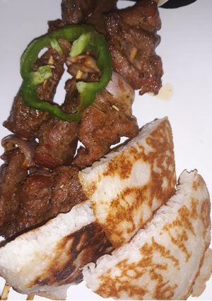 A picture of Rice pancakes with roasted beef on skewers.
