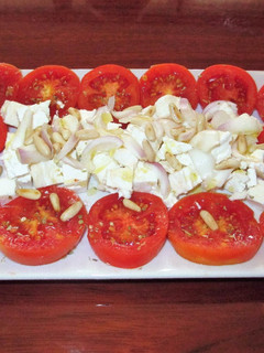 Una foto de Ensalada de tomates con queso y piñonesal orégano