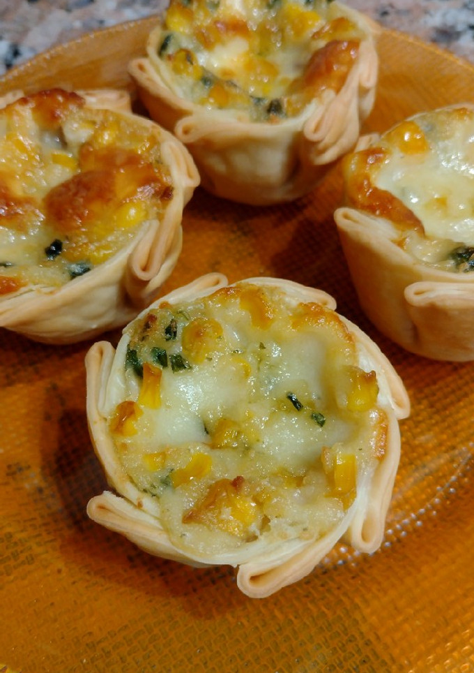 Una foto de Canastitas de choclo amarillo y salsa blanca