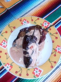 Una foto de Chiles rellenos bañados en crema de nuez moscada