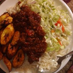 A picture of Rice and stew with plaintain.