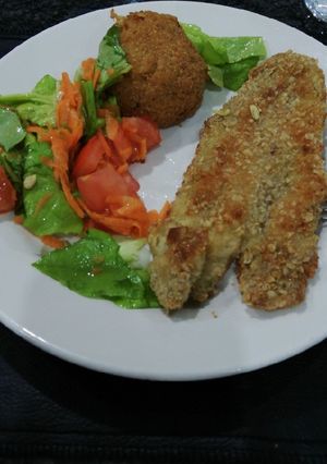 Una foto de Milanesas de merluza con ensalada y bomba de arroz
