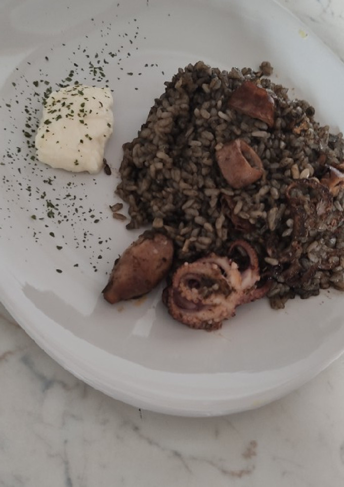 Una foto de Arroz negro con pulpitos y chipirones