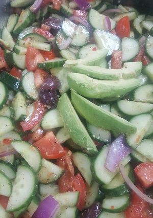A picture of Greek tomato and cucumber salad with avocados.