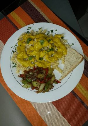 Una foto de Pasta en crema de auyama con queso, y ensalada de vegetales salteados