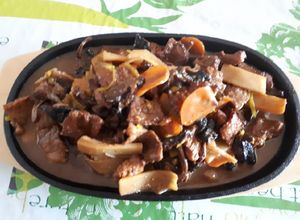 Une photo de Veau aux champignons shiitakes frais sur plaque chauffante