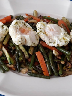 Una foto de Verdura salteada con frutos secos y huevo poché