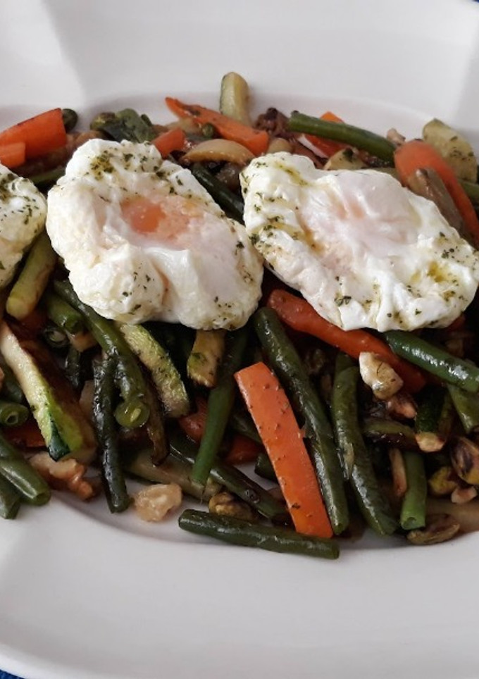 Una foto de Verdura salteada con frutos secos y huevo poché