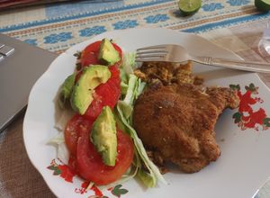 Una foto de Posta de cerdo empanizada con ensalada